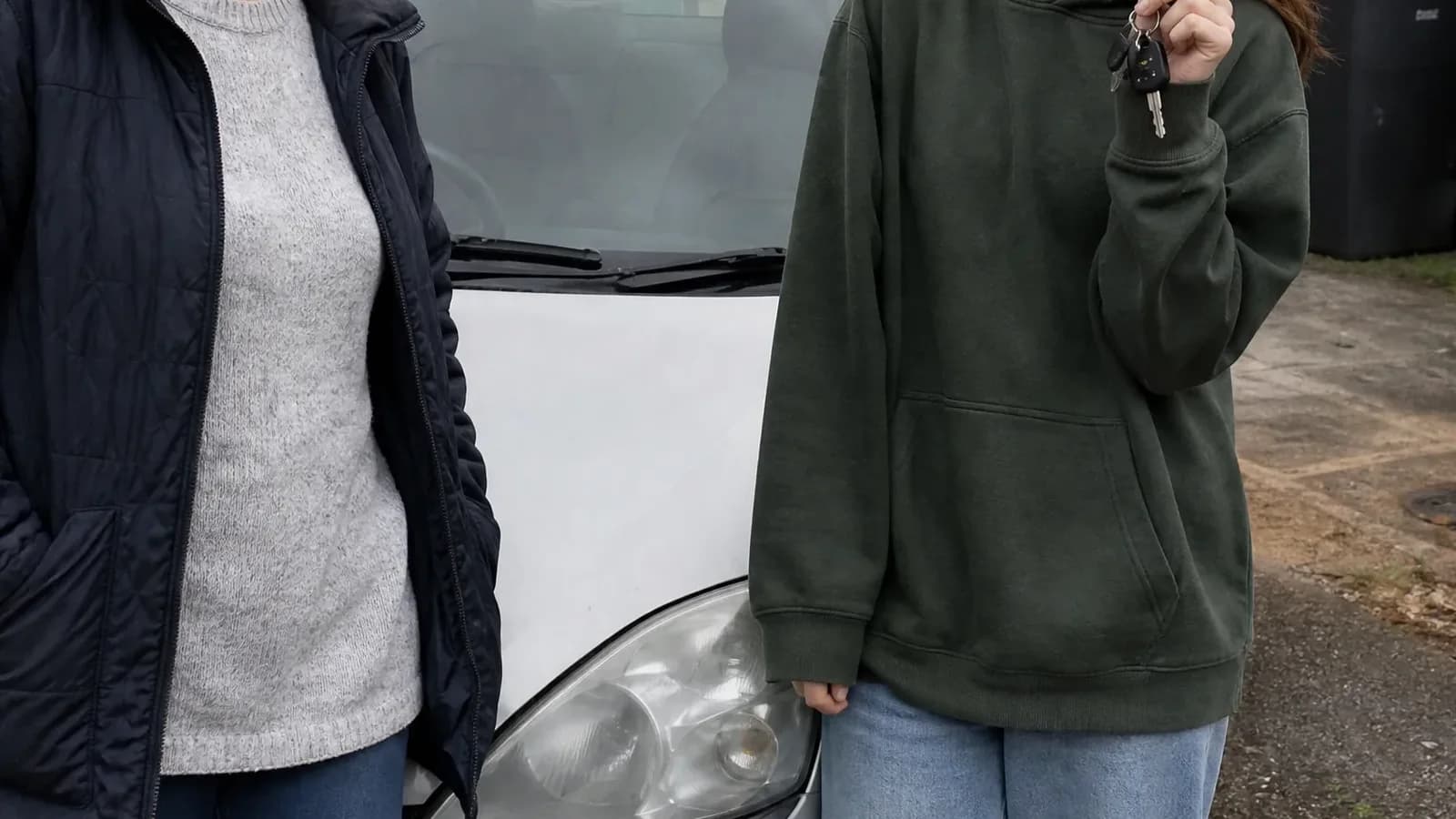 A mum and her teenage daughter on the drive beside the daughter's first car